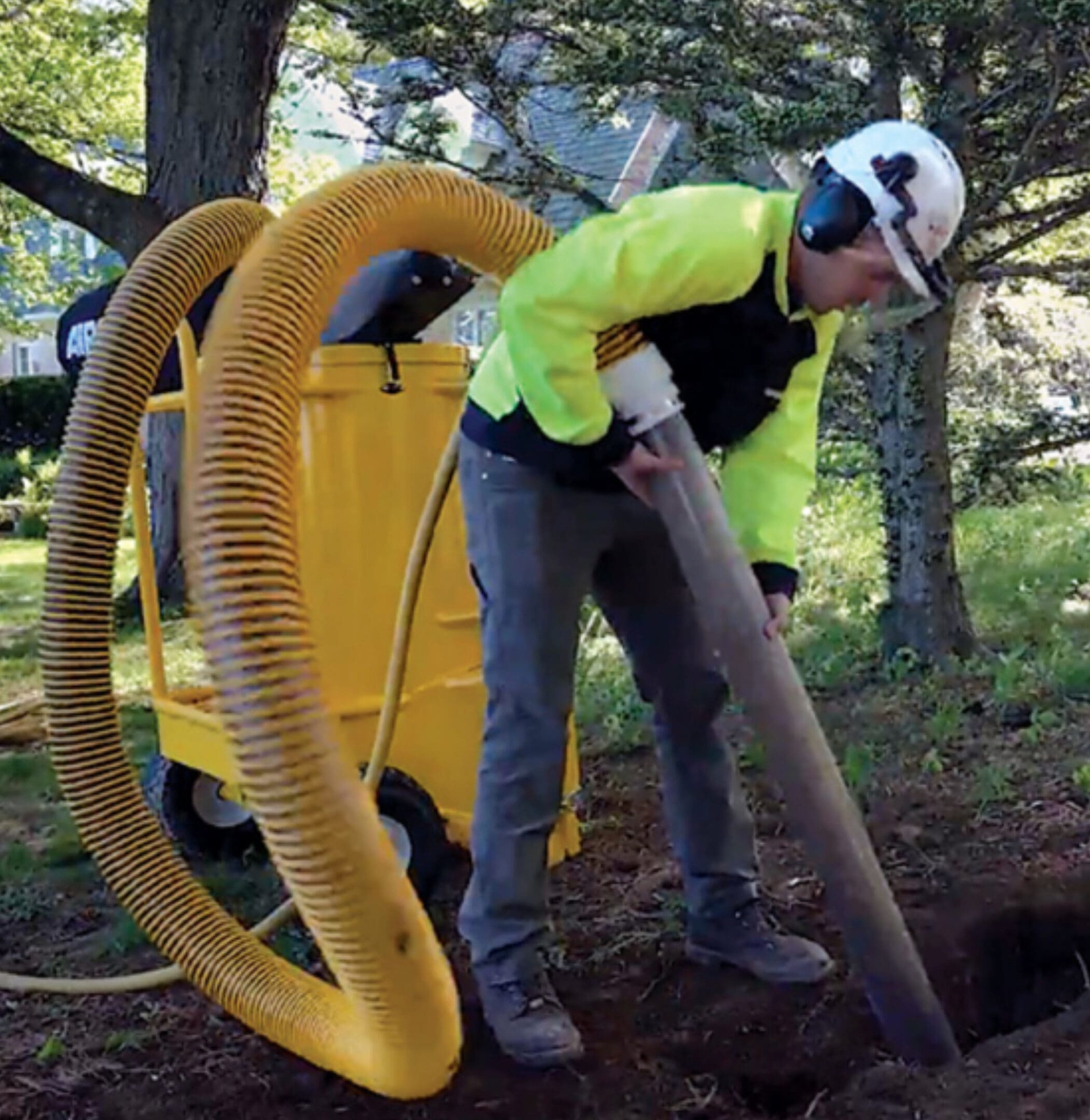 A worker uses a vacuum to remove debris.