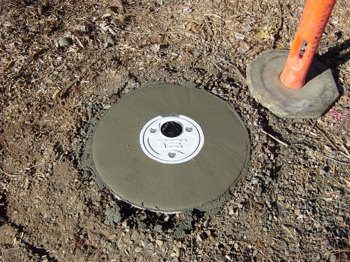 Concrete base with a white access cover.