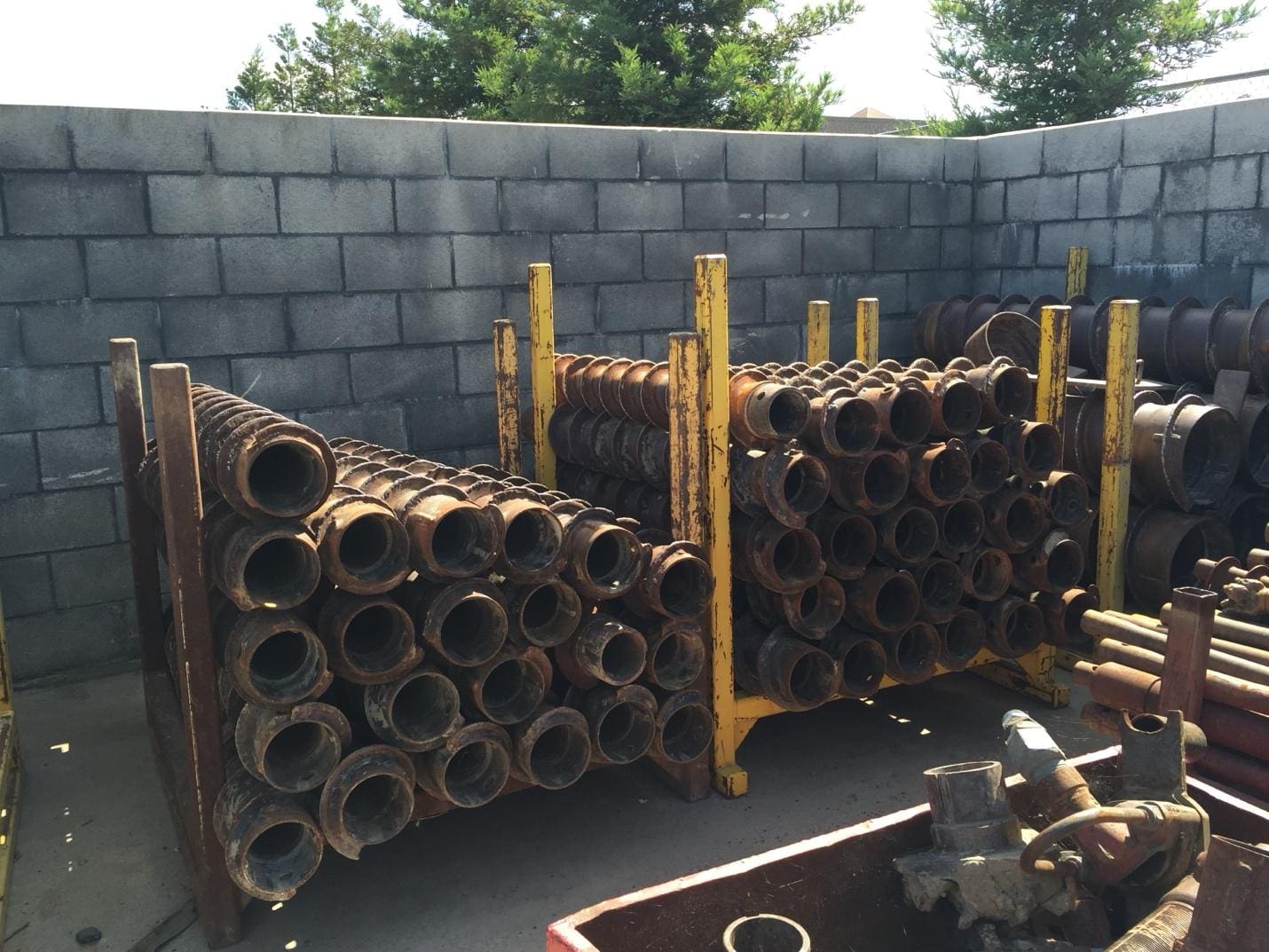 Stacked metal pipes in a storage yard.