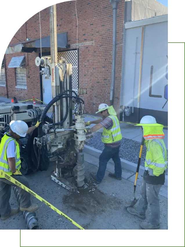 Construction workers using drilling equipment.