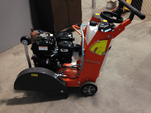 Orange and black concrete cutting saw.