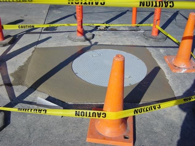 Freshly poured concrete around manhole cover.