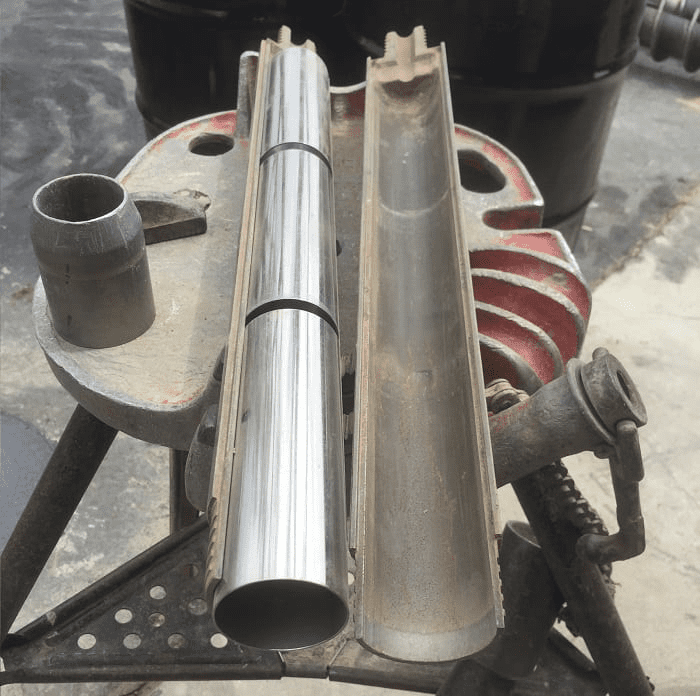 Two metal pipes on a workbench.